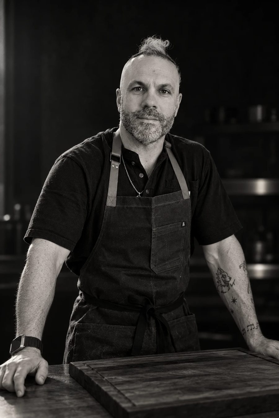 Chef Marco in an apron, hands on a wooden cutting board
